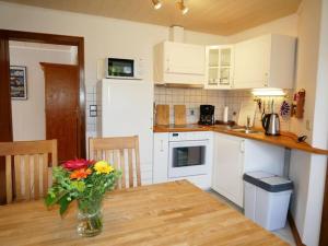 a kitchen with a table with a vase of flowers on it at Lovely apartment in Apartment Lina in Pilsum