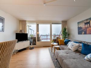 a living room with a couch and a tv at Cozy Holiday Home in Hasselt Near By The Water in Hasselt