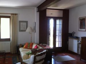 een woonkamer met een bank en een raam bij Chalet with garden, terrace and barbecue in Pastrengo