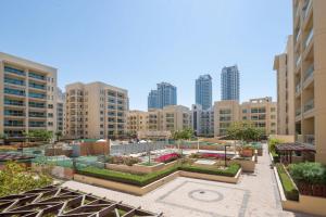 a courtyard in a city with tall buildings at Frank Porter - Al Dhafrah 2 in Dubai