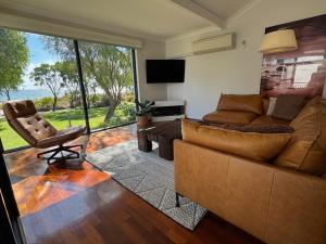 a living room with a couch and a chair at 5@CapeView, beachfront Geographe Bay in Busselton