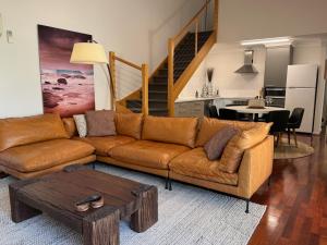 sala de estar con sofá marrón y mesa en 5@CapeView, beachfront Geographe Bay, en Busselton