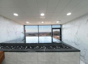 a room with a bath tub with a large window at WJ Hotel Pool House in Wonju