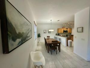 a dining room and kitchen with a table and chairs at Panoramic 4BR Superior Pool Home near Disney Parks in Davenport