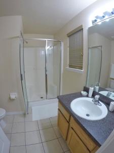 ein Bad mit einem Waschbecken und einer Dusche in der Unterkunft Panoramic 4BR Superior Pool Home near Disney in Davenport