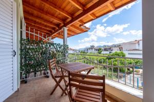a patio with a table and chairs on a balcony at Eagle's Nest City Apartments in Aígio