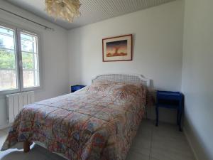 um quarto com uma cama, uma janela e um lustre em Maison La Faute-sur-Mer, 3 pièces, 4 personnes - FR-1-476-187 em La Faute-sur-Mer