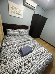 una camera da letto con un letto con un piumone bianco e nero di One Oasis Condo 2 Bedroom Free Pool & Wifi Beside SM City Mall a Davao