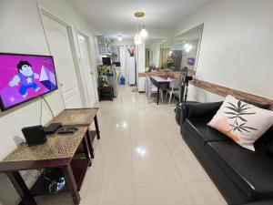 a living room with a couch and a tv at One Oasis Condo 2 Bedroom Free Pool & Wifi Beside SM City Mall in Davao City