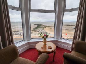 a room with a table and two chairs and a large window at Eden Bay Retreat in Morecambe
