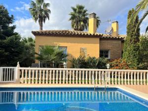 una casa con una recinzione bianca e una piscina di Casa Sant Pere Pescador, 3 dormitorios, 6 personas - ES-89-74 a Sant Pere Pescador