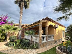 una casa gialla con balcone e palme di Casa Sant Pere Pescador, 3 dormitorios, 6 personas - ES-89-74 a Sant Pere Pescador