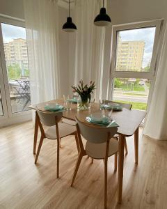 une salle à manger avec une table et des chaises en bois ainsi qu'une table et des chaises dans l'établissement Mint House Apartment, à Varsovie