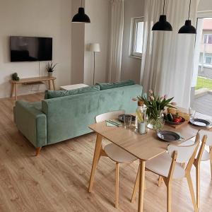 - un salon avec un canapé vert et une table dans l'établissement Mint House Apartment, à Varsovie