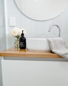 encimera con lavabo y espejo en Banksia Beach House en Port Fairy