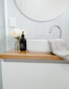 a bathroom counter with a sink and a mirror at Banksia Beach House in Port Fairy