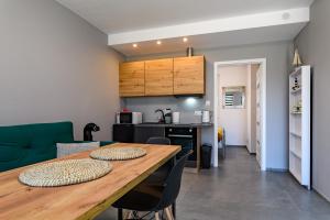 加茨比亞格拉的住宿－Apartament Wiatrakowa，厨房以及带木桌和椅子的用餐室。
