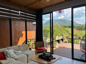a living room with a couch and a view of a balloon at Ogimi Villas Bảo Lộc in Blao Srê