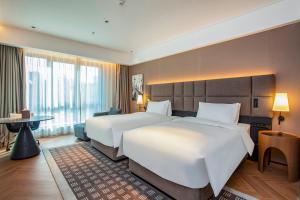 Postel nebo postele na pokoji v ubytování Nanjing Fanyue Plaza Intercity Hotel