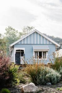 una casa azul sentada en la cima de una colina en Sailors Whisk, luxurious restored antique cottage en Flinders