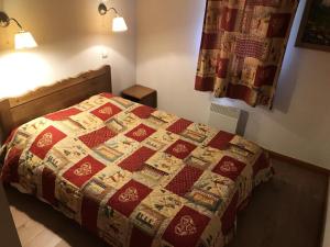 a bedroom with a bed with a quilt on it at Résidence Dryades Hameau De La Vallee D'or - 3 Pièces pour 6 Personnes 14 in Valloire