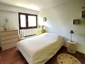 1 dormitorio con cama blanca y ventana en Appartement Seignosse, 3 pièces, 5 personnes - FR-1-239-959, en Seignosse
