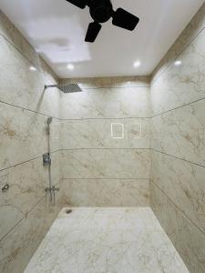 a bathroom with a shower with a ceiling fan at MG apartments in Jodhpur