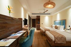 a hotel room with two beds and a desk at MGM Beach Resorts East Coast Road in Chennai