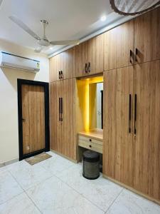 MG apartments في جودبور: غرفة بها دواليب خشبية ومغسلة ومرآة