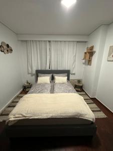 ein Schlafzimmer mit einem großen Bett in einem weißen Zimmer in der Unterkunft Nancy & Vaggelis Holiday Studios in Litochoro