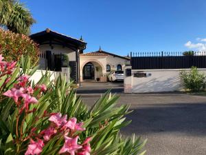 a house with pink flowers in front of a driveway at Les Cottages du Bassin d'Arcachon -Proche Parc Ornithologique-Dune du Pilat- Clim- Parking privé in Gujan-Mestras