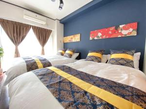 Duas camas num quarto com paredes azuis em ファースト天王寺東501 em Osaka