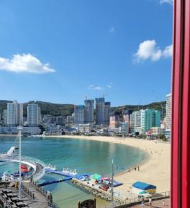 vistas a la playa y a una ciudad con edificios en Q5 Hotel Busan Songdo, en Busan