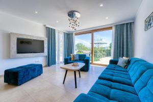 a living room with a blue couch and a table at Villa Mare With Private Pool And Garden - Happy Rentals in Malinska