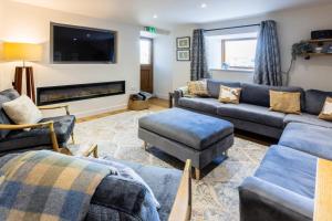 a living room with couches and a flat screen tv at Linton Laithe in Skipton