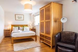 a bedroom with a bed and a chair at Linton Laithe in Skipton