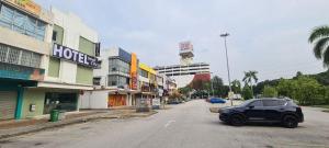 a car parked on a street in front of buildings at Small City Hotel in Klang