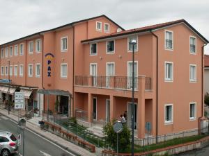 un gran edificio naranja al lado de una calle en Residence Pax en Fiumaretta di Ameglia