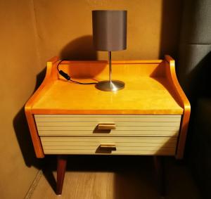 a nightstand with a lamp on top of it at Ferienhaus Emilia in Wilthen