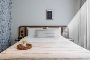 a bedroom with a white bed with a basket on it at 202 Elizabeth Hotel - The Surry - Australia in Sydney