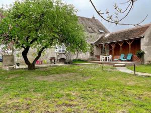 ein Haus mit einem Baum und Stühlen im Hof in der Unterkunft Gîte Manthelan, 3 pièces, 4 personnes - FR-1-381-574 in Manthelan