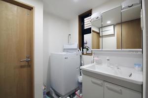 TOKYO MY HOME في طوكيو: حمام مع مغسلة وثلاجة بيضاء