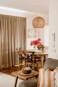 a dining room with a table and chairs and curtains at Banksia Beach House in Port Fairy