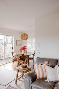 a living room with a couch and a table at Banksia Beach House in Port Fairy