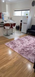 a living room with a pink rug and a kitchen at One bedroom Apartment in Local shopping mall in Melbourne
