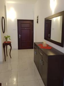 een badkamer met een wastafel, een spiegel en een deur bij Meadows Living 2 BR Apartment near Mount Beach in Karagampitiya