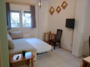 a bedroom with a bed and a couch and a table at Elpida's houses 1 Private parking Near city centre in Thessaloniki