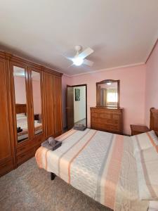 a bedroom with a bed and a dresser and a mirror at Gabriella Apartment Near the beach in Puerto de Sagunto