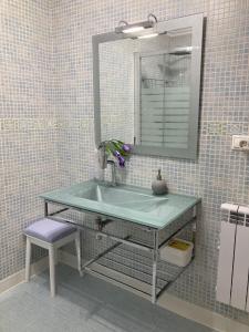 baño con lavabo verde y espejo en La buhardilla d, en San Clemente
