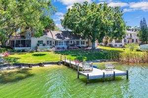 ein Dock in der Mitte eines Sees mit einem Haus in der Unterkunft Lake Silver V - Lake House with Dock - Legoland Getaway! in Winter Haven